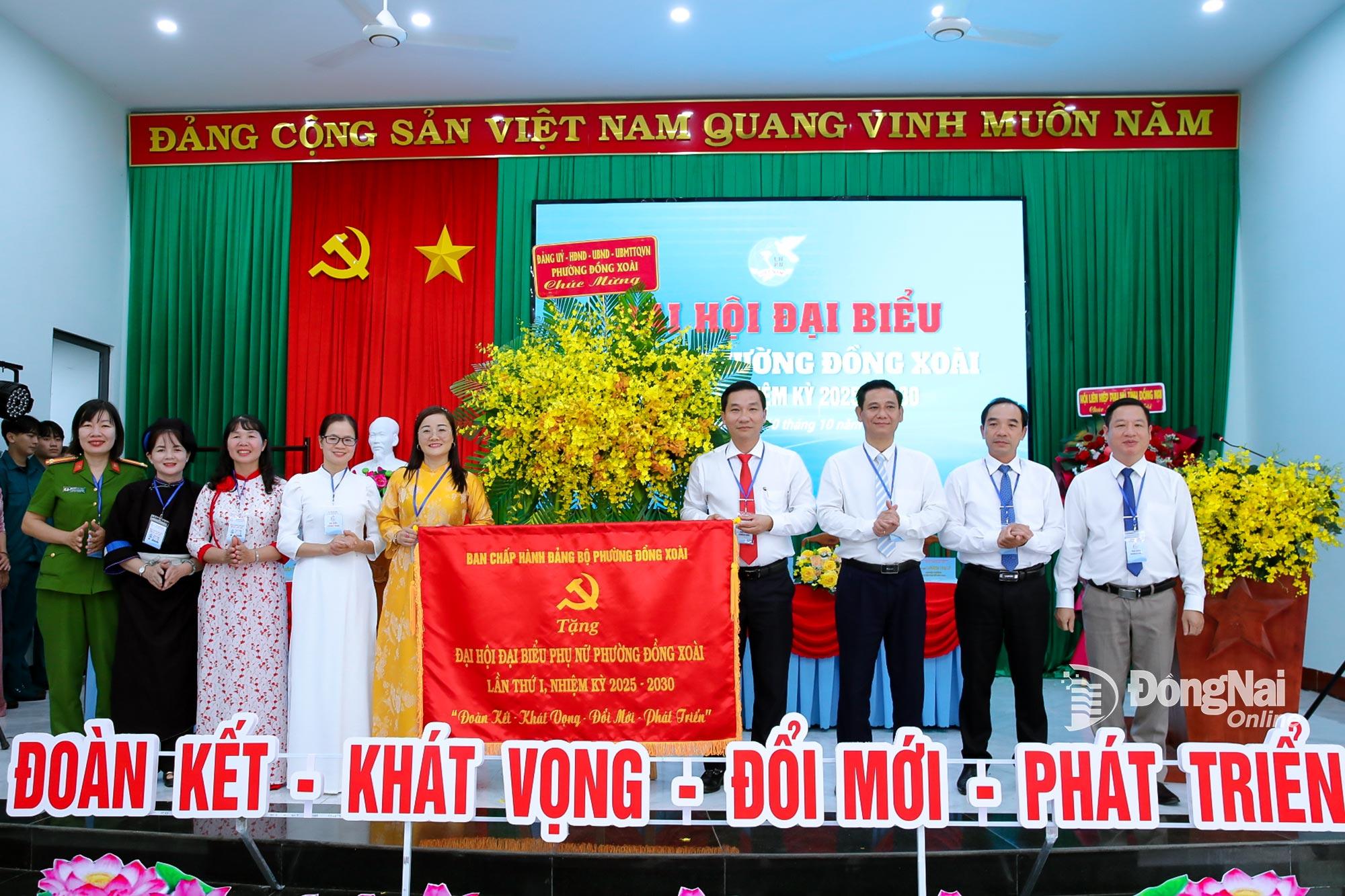 Thường trực Đảng ủy, HĐND, UBND, Ủy ban MTTQ Việt Nam phường Đồng Xoài tặng hoa và bức trướng chúc mừng đại hội. Ảnh: Trương Hiện