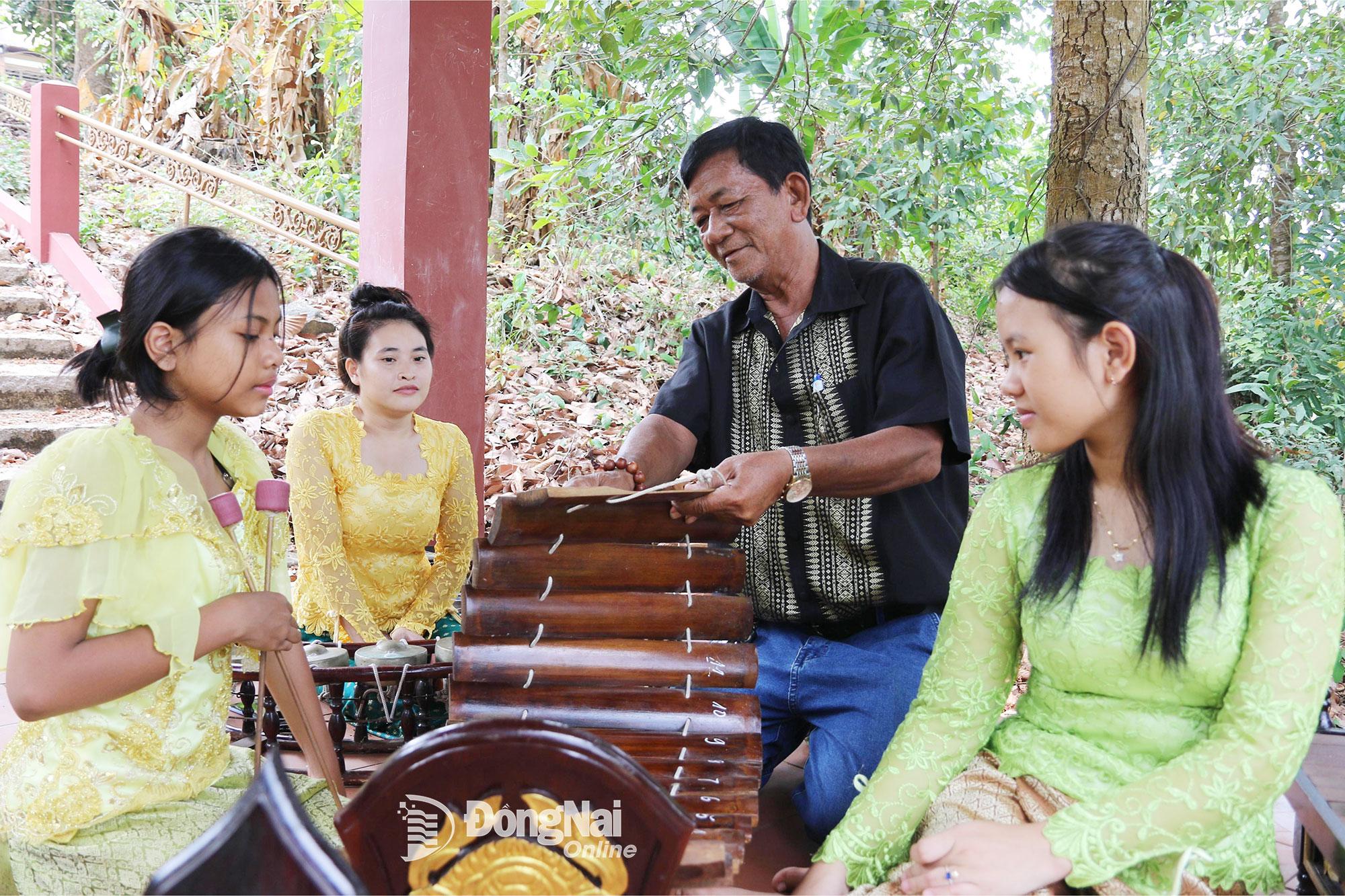 Người có uy tín trong đồng bào dân tộc thiểu số tỉnh Đồng Nai Lâm Chơn Nam (dân tộc Khmer, ngụ xã Định Quán) hướng dẫn thanh niên tham gia lớp nhạc ngũ âm. Ảnh: Văn Truyên