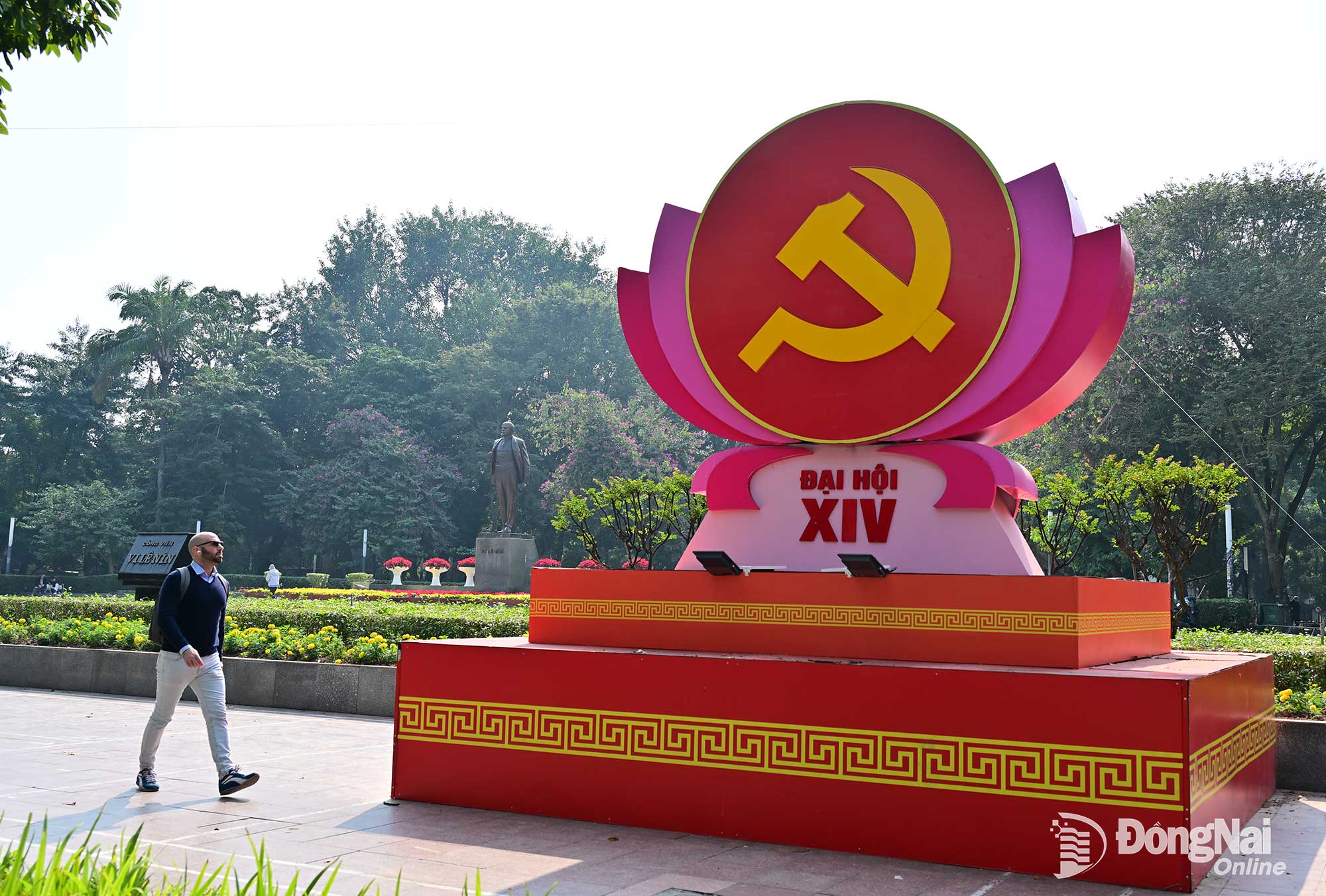 Một người nước ngo&agrave;i đi qua c&ocirc;ng vi&ecirc;n L&ecirc; Nin, nơi được trang ho&agrave;ng ch&agrave;o mừng Đại hội XIV. Ảnh: C&ocirc;ng Nghĩa  