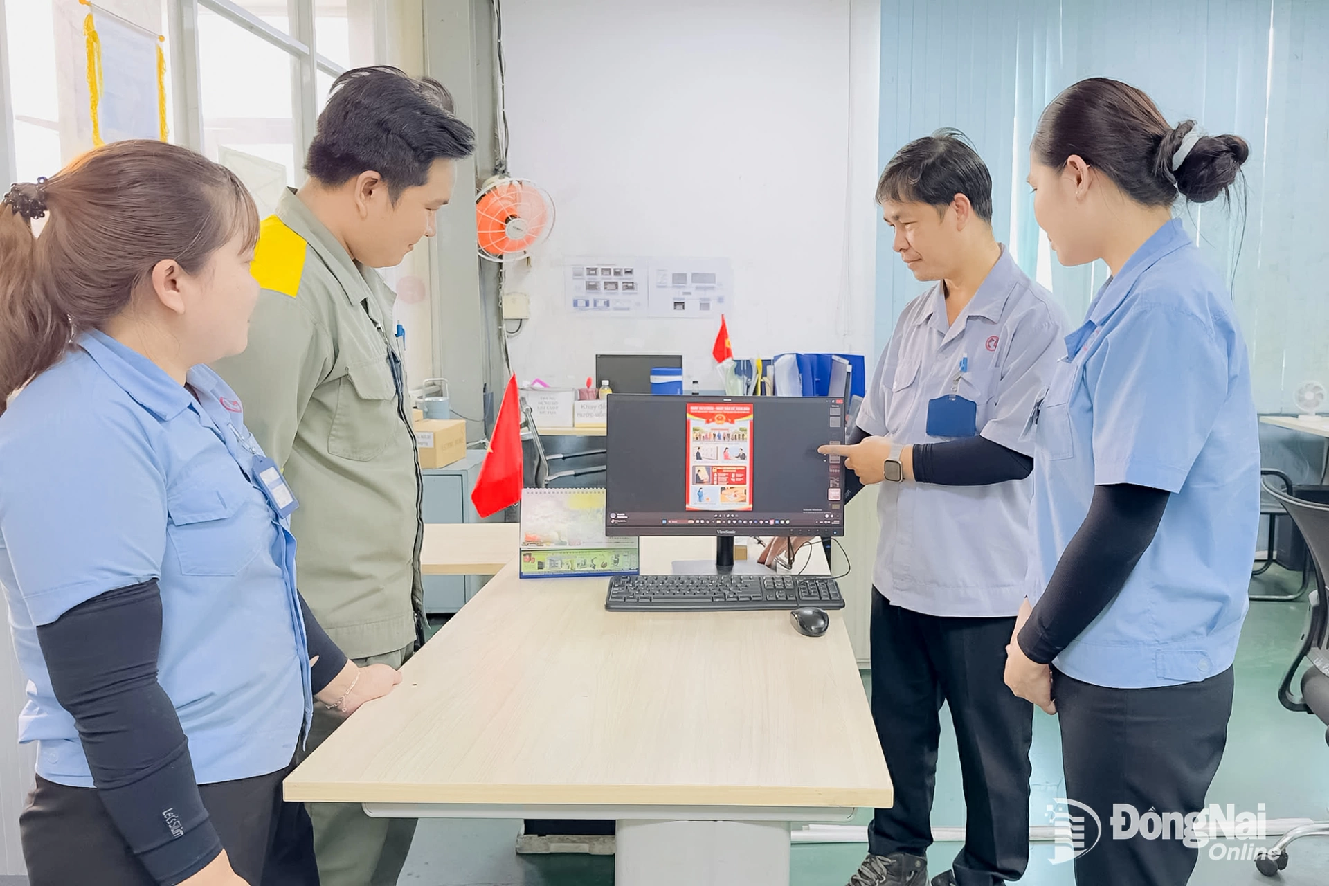 Anh Dương Công Khuê (thứ 2 từ phải qua), đảng viên Công ty hữu hạn Cơ khí động lực Toàn Cầu tuyên truyền bầu cử cho đoàn viên. Ảnh: Nguyễn Hòa