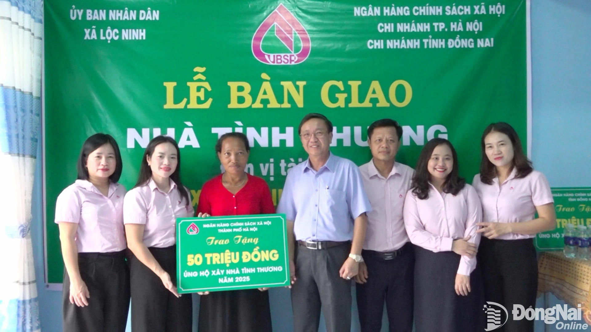 Lãnh đạo Chi nhánh Ngân hàng Chính sách xã hội Hà Nội và tỉnh Đồng Nai trao biển tượng trưng cho hộ bà Thị Mai. Ảnh: Văn Hùng