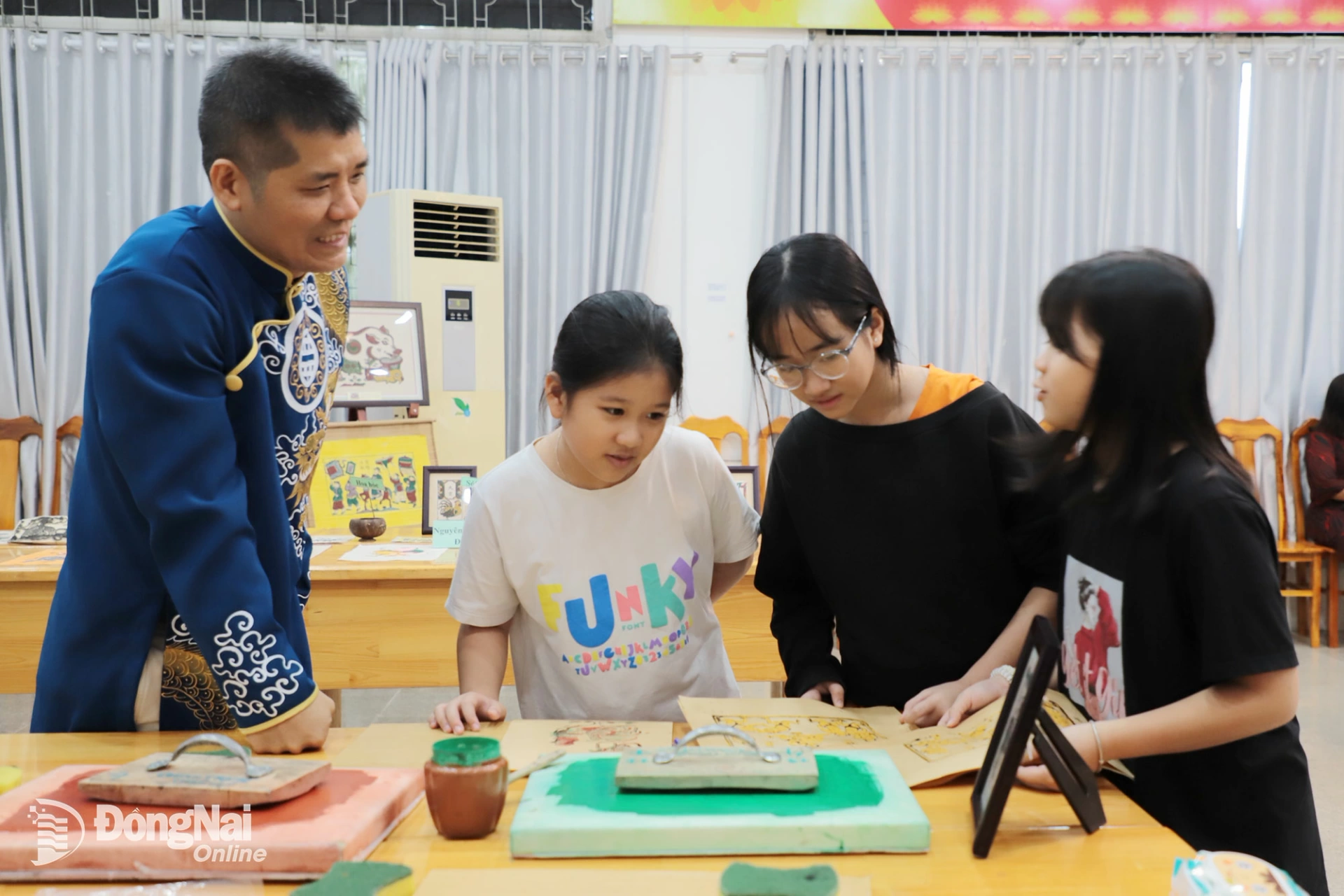 Nghệ nhân Đỗ Đức Thuận hướng dẫn các em học sinh ở Đồng Nai thực hiện các bước làm tranh dân gian Đông Hồ. Ảnh: Cẩm Thành