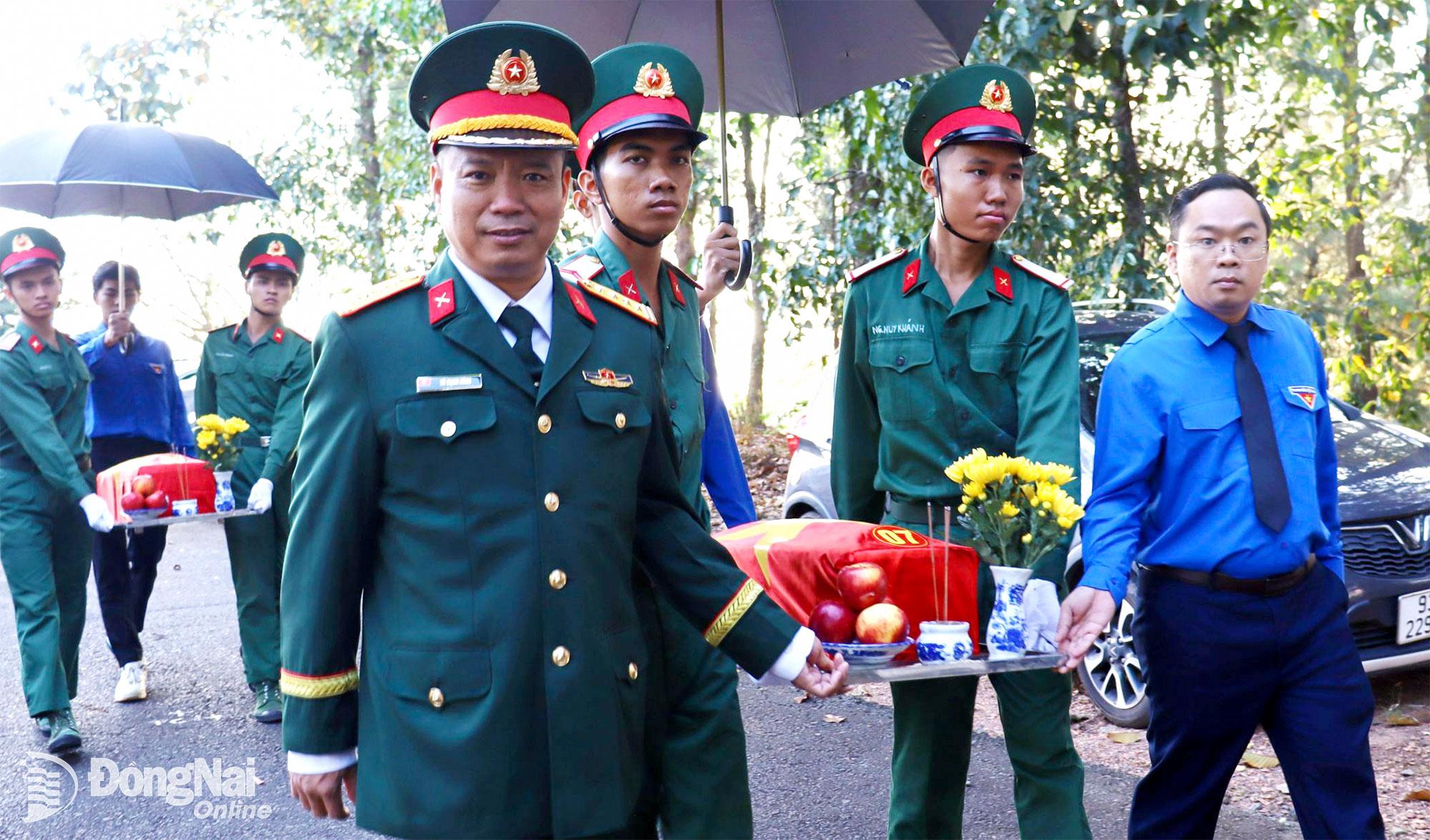 Tỉnh ủy viên, Phó Chủ tịch Ủy ban MTTQ Việt Nam tỉnh, Bí thư Tỉnh đoàn Nguyễn Minh Kiên và Đại tá Vũ Mạnh Hùng, Phó Chỉ huy trưởng Bộ Chỉ huy Quân sự tỉnh Đồng Nai di quách hài cốt liệt sĩ về nơi an táng. Ảnh: Nguyệt Hà