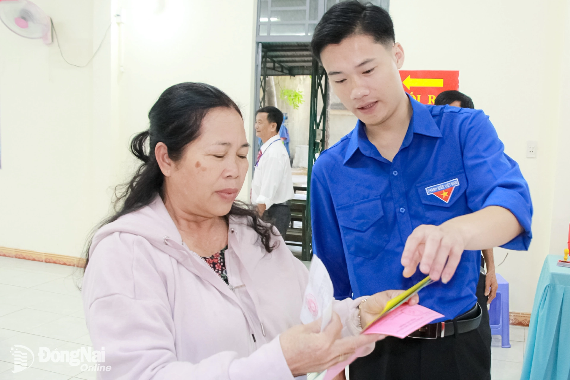 Đoàn viên thanh niên phường Hố Nai giải đáp thắc mắc của người dân tại khu vực bỏ phiếu. Ảnh: Nga Sơn