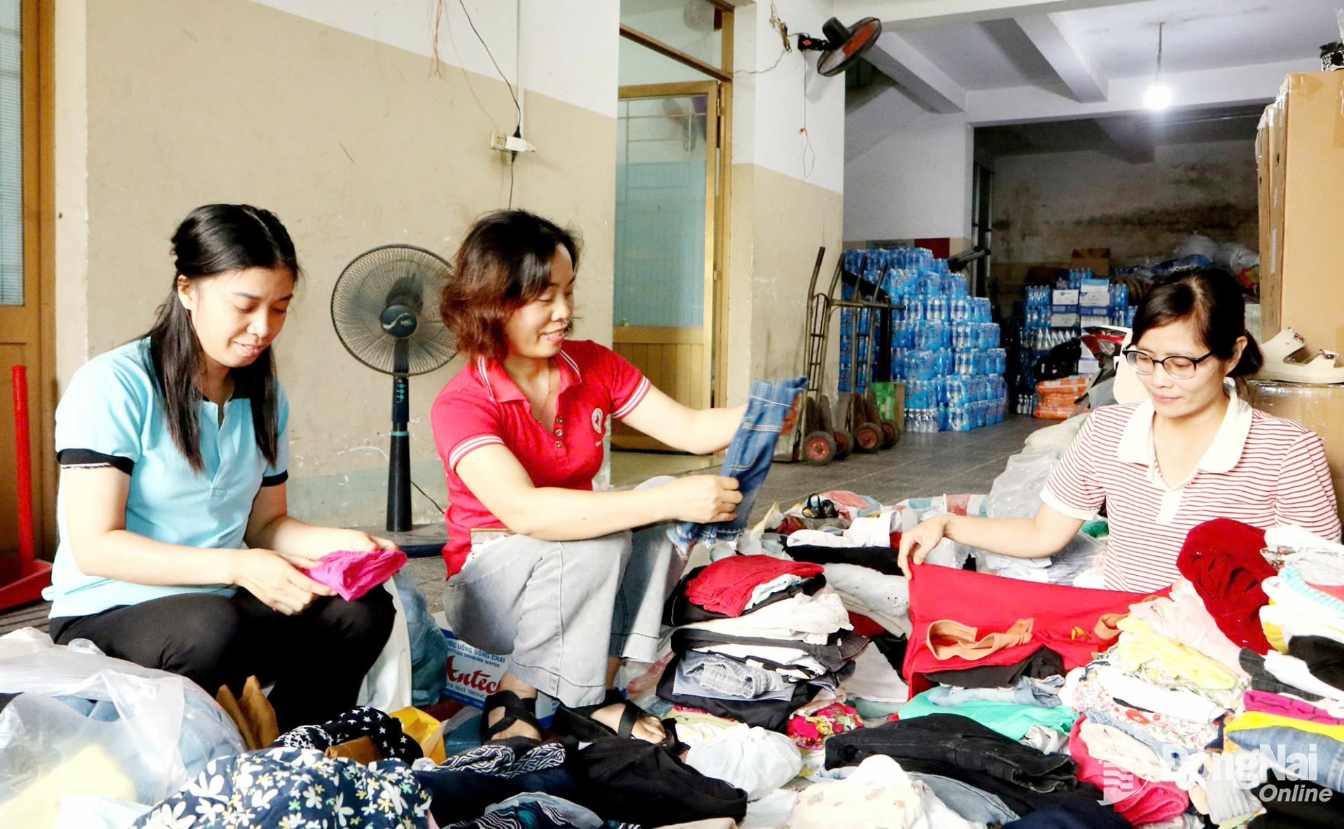 Người lao động Hội Chữ thập đỏ tỉnh Đồng Nai sắp xếp, phân loại quần áo được người dân ủng hộ đồng bào khắc phục thiệt hại do mưa bão gây ra. Ảnh: Văn Truyên