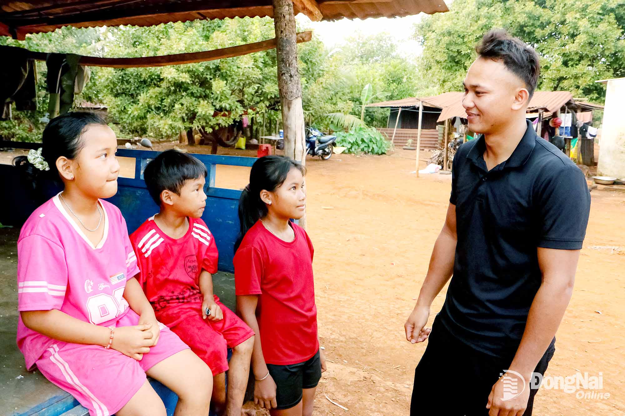 Anh Điểu Tiêu Phi (ở xã Phú Nghĩa) trò chuyện với các em học sinh trong cộng đồng. Ảnh: Văn Truyên    