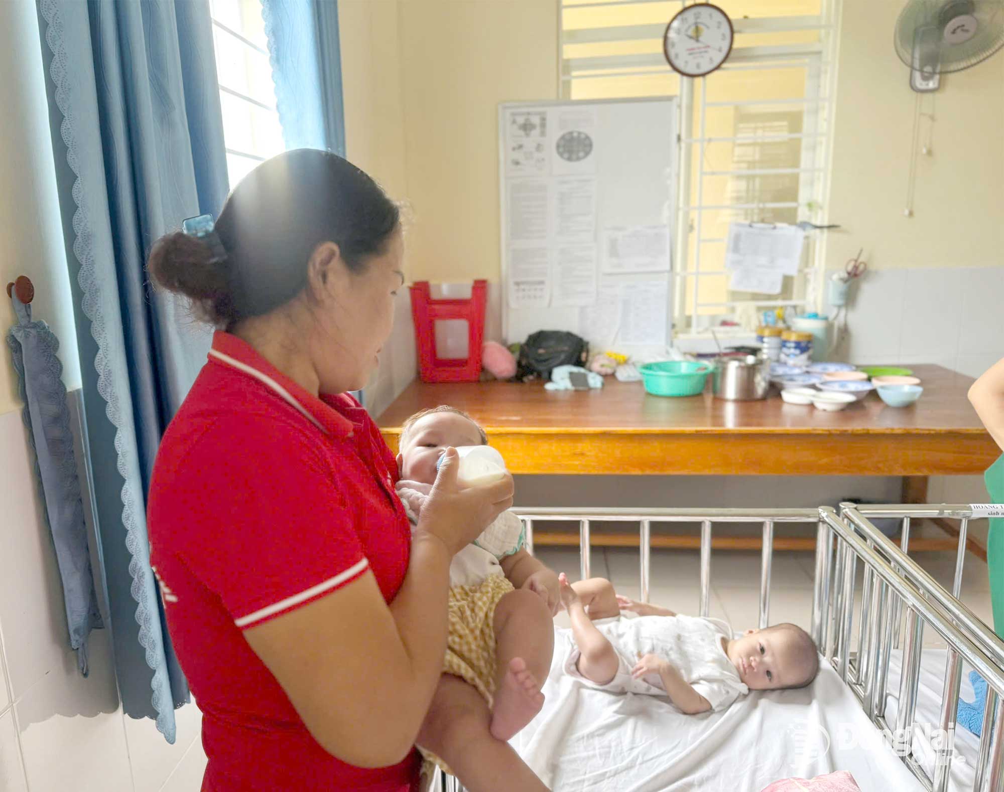 Chị Nguyễn Thị Hạnh, nhân viên tại Trung tâm Công tác xã hội và Quỹ Bảo trợ trẻ em phường Tam Hiệp chăm sóc các trẻ bị bỏ rơi. Ảnh: Bích Nhàn