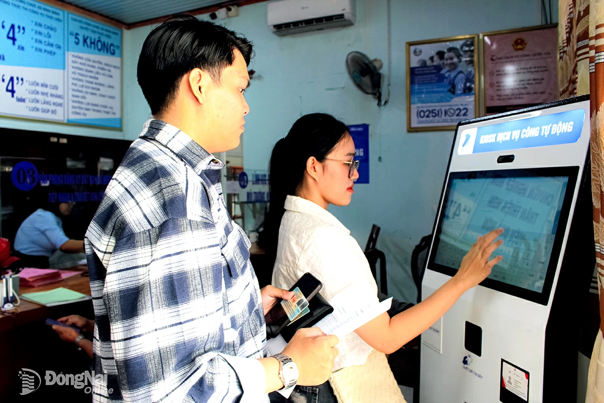 Chị Trần Thị Kim Ngân và anh Lê Thành Đạt thực hiện thao tác trên ki-ốt dịch vụ công để thực hiện thủ tục đăng ký kết hôn tại Trung tâm Phục vụ hành chính công xã Bình Minh. Ảnh: Hồ Thảo