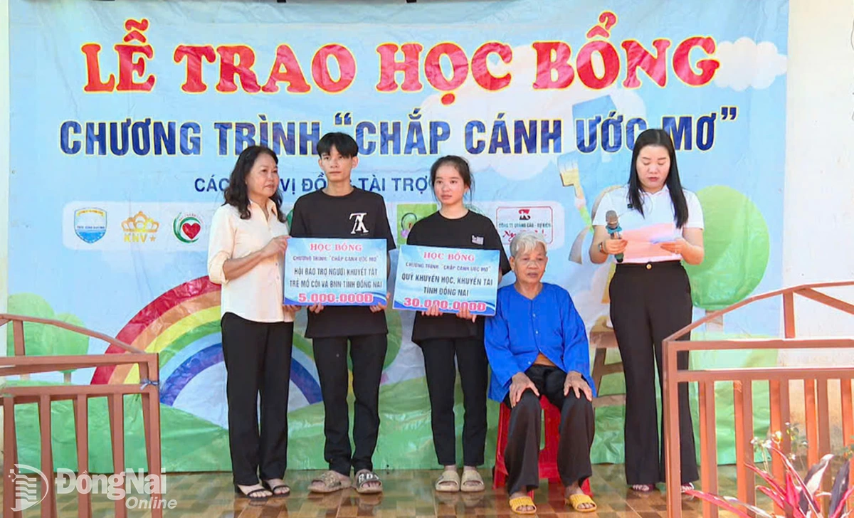 B&agrave; B&ugrave;i Thị Hương, Ph&oacute; Chủ tịch Hội Bảo trợ người khuyết tật, trẻ mồ c&ocirc;i v&agrave; bệnh nh&acirc;n ngh&egrave;o tỉnh Đồng Nai trao học bổng 5 triệu đồng cho Nam. Ảnh: Ph&uacute; Q&uacute;y