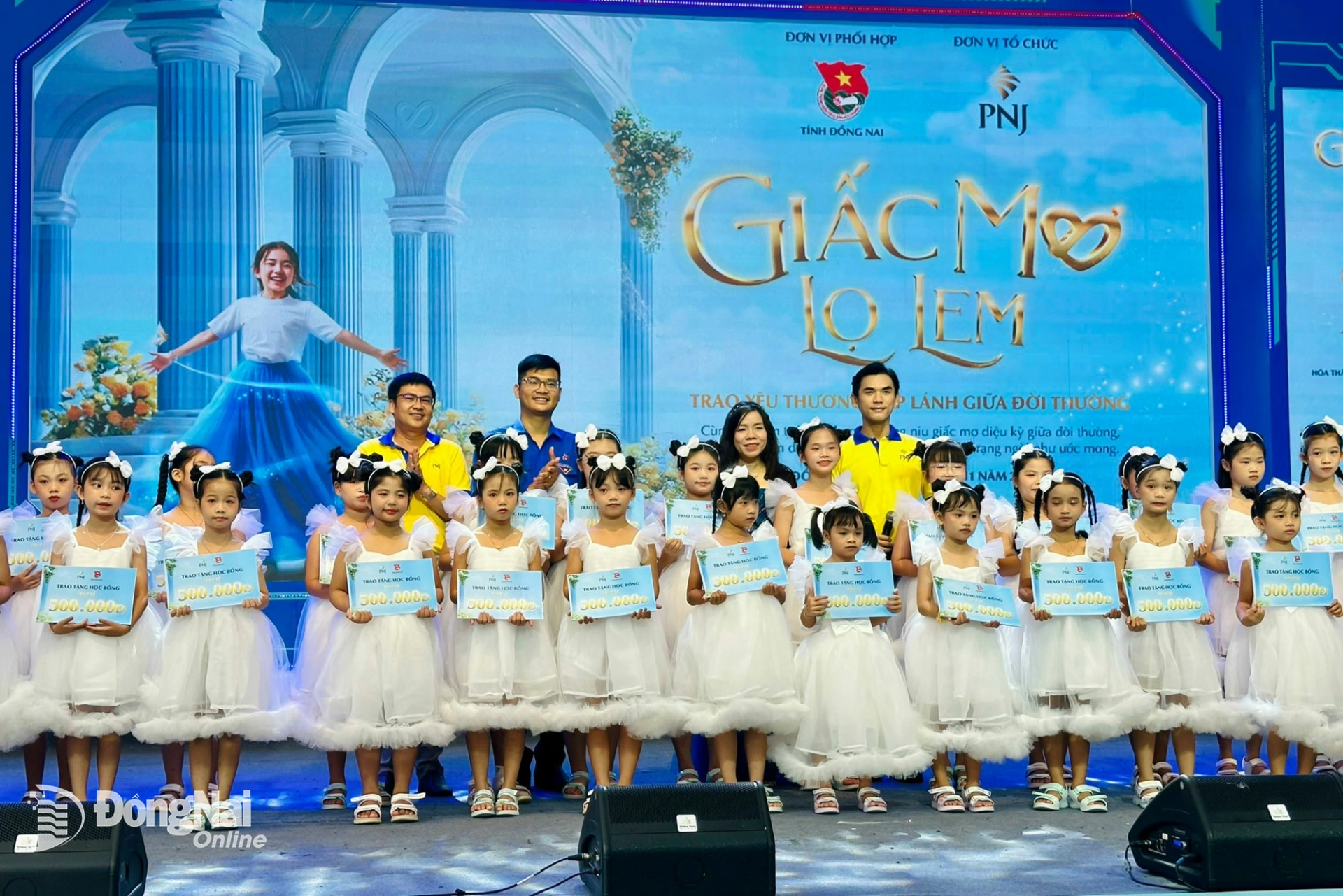 Ban tổ chức Ngày hội “Giấc mơ Lọ Lem” trao học bổng cho các em thiếu nhi khó khăn. Ảnh: Hồng Phương  