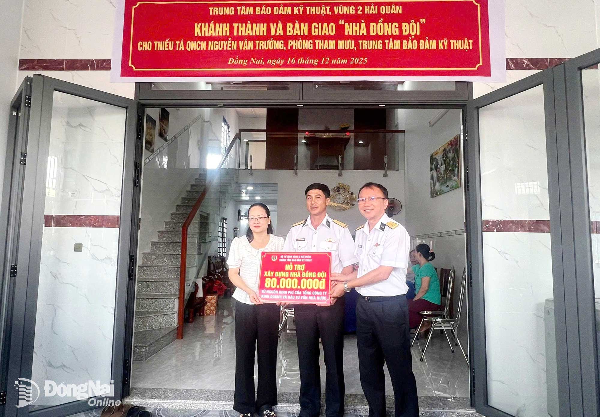 Thượng tá Nguyễn Hùng Vỹ (bìa phải), Phó Chính ủy Trung tâm trao tiền hỗ trợ cho gia đình. Ảnh: Tấn Sang