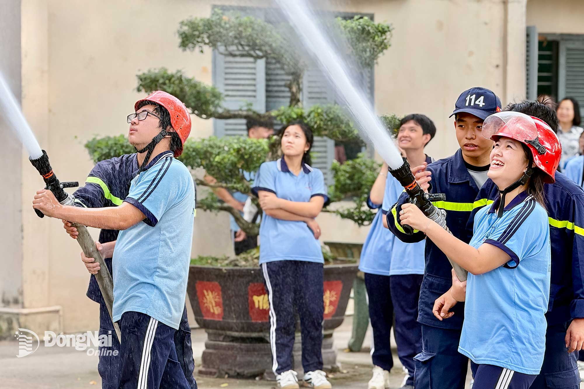 C&aacute;c em học sinh Trường THPT Nguyễn Đ&igrave;nh Chiểu (x&atilde; Long Th&agrave;nh) được hướng dẫn sử dụng v&ograve;i chữa ch&aacute;y chuy&ecirc;n dụng. Ảnh: Đăng T&ugrave;ng