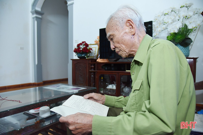 Trung tá Phan Xuân Đức lật giở lại những trang giấy đã ố màu thời gian ghi lại quá trình công tác đã qua.