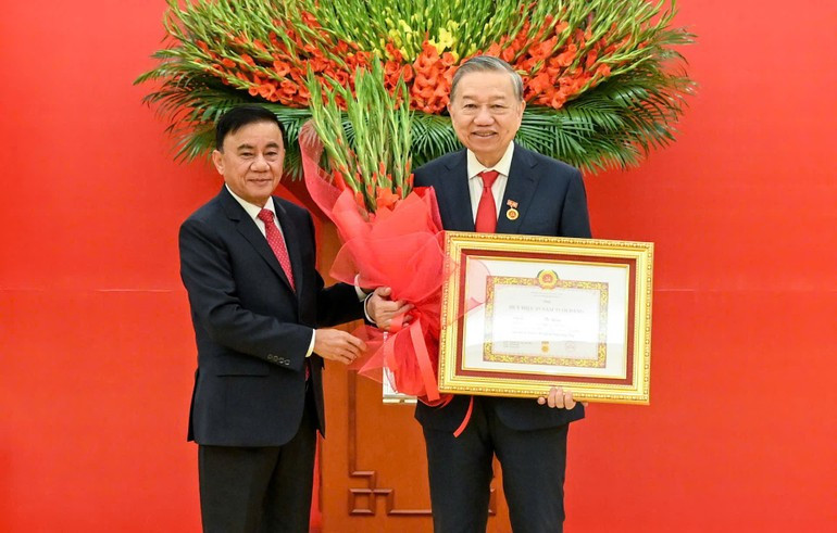 Thường trực Ban B&iacute; thư Trần Cẩm T&uacute; trao Huy hiệu 45 năm tuổi đảng, tặng hoa ch&uacute;c mừng đồng ch&iacute; T&ocirc; L&acirc;m, Tổng B&iacute; thư Ban Chấp h&agrave;nh Trung ương Đảng Cộng sản Việt Nam. (Ảnh: DUY LINH)