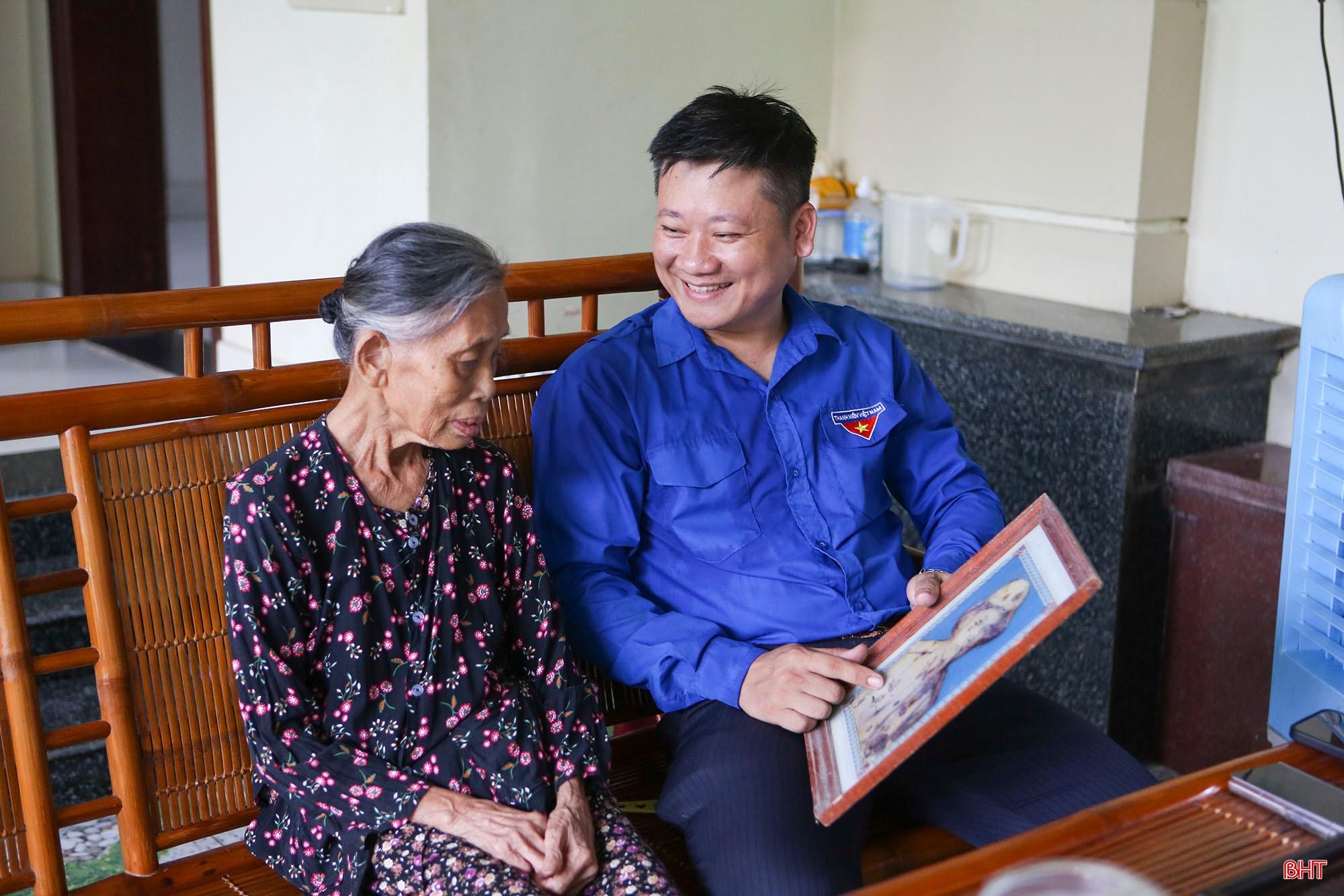 Anh Đặng Văn Cường cùng bà ngoại xem lại bức hình kỷ niệm của ông ngoại là cụ Nguyễn Văn Bật (1932-2021) chụp thời kỳ tham gia kháng chiến chống Pháp. bqbht_br_a7.jpg