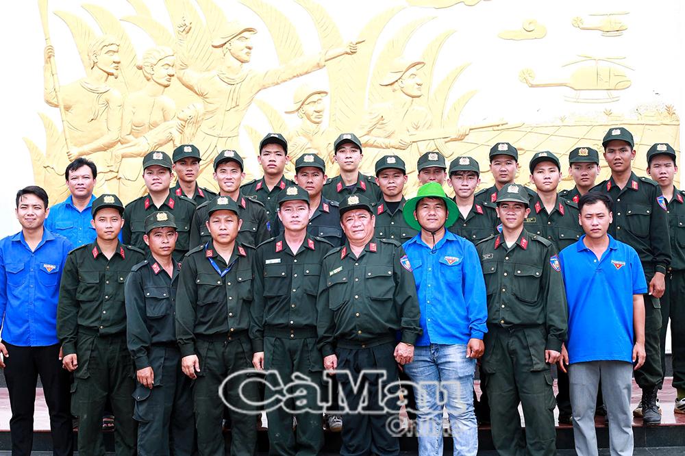 Cán bộ, chiến sĩ Tiểu đoàn Cảnh sát cơ động số 4 và đoàn viên, thanh niên xã Vĩnh Mỹ chụp ảnh lưu niệm trước Bia tưởng niệm Đôn Bơ - Cựa Gà (tại ấp Thạnh Hưng II).