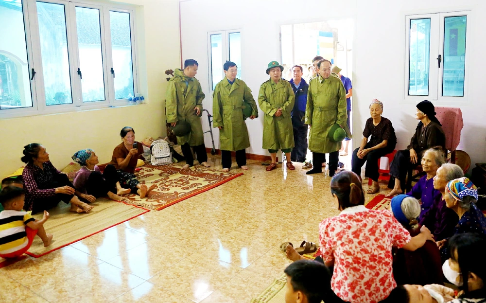 Đồng chí Chủ tịch HĐND tỉnh Nguyễn Đăng Bình cùng Đoàn công tác động viên bà con nhân dân vùng ngập lụt ở phường Trung Thành, hiện đã được sơ tán đến nơi an toàn.