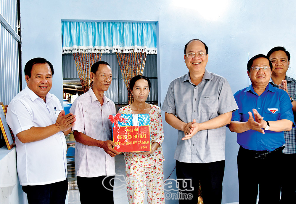 &ETH;ồng ch&iacute; Nguyễn Hồ Hải, B&iacute; thư Tỉnh uỷ (thứ tư từ tr&aacute;i sang) tặng qu&agrave; cho hộ d&acirc;n được hỗ trợ nh&agrave; tại phường Ho&agrave; Th&agrave;nh. (Ảnh: MỘNG THƯỜNG)