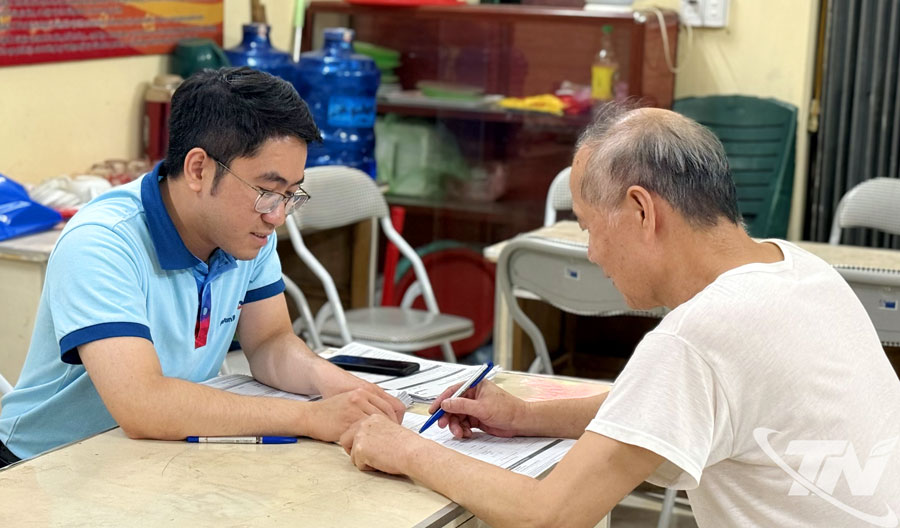 Cán bộ Ngân hàng VietinBank hướng dẫn người dân sử dụng ứng dụng thanh toán không dùng tiền mặt tại điểm hỗ trợ tổ 3A, phường Đức Xuân.