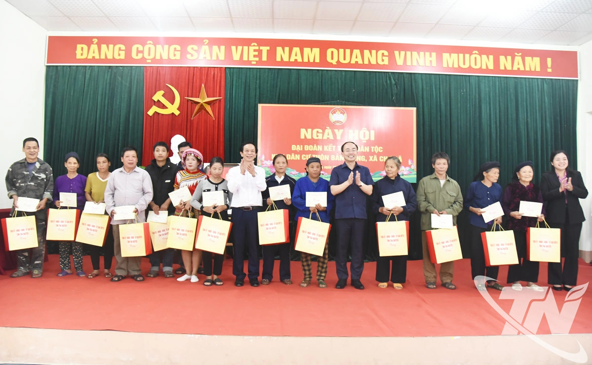 Đồng chí Nguyễn Đăng Bình tặng quà cho các hộ gia đình còn khó khăn trong thôn Bản Piềng.