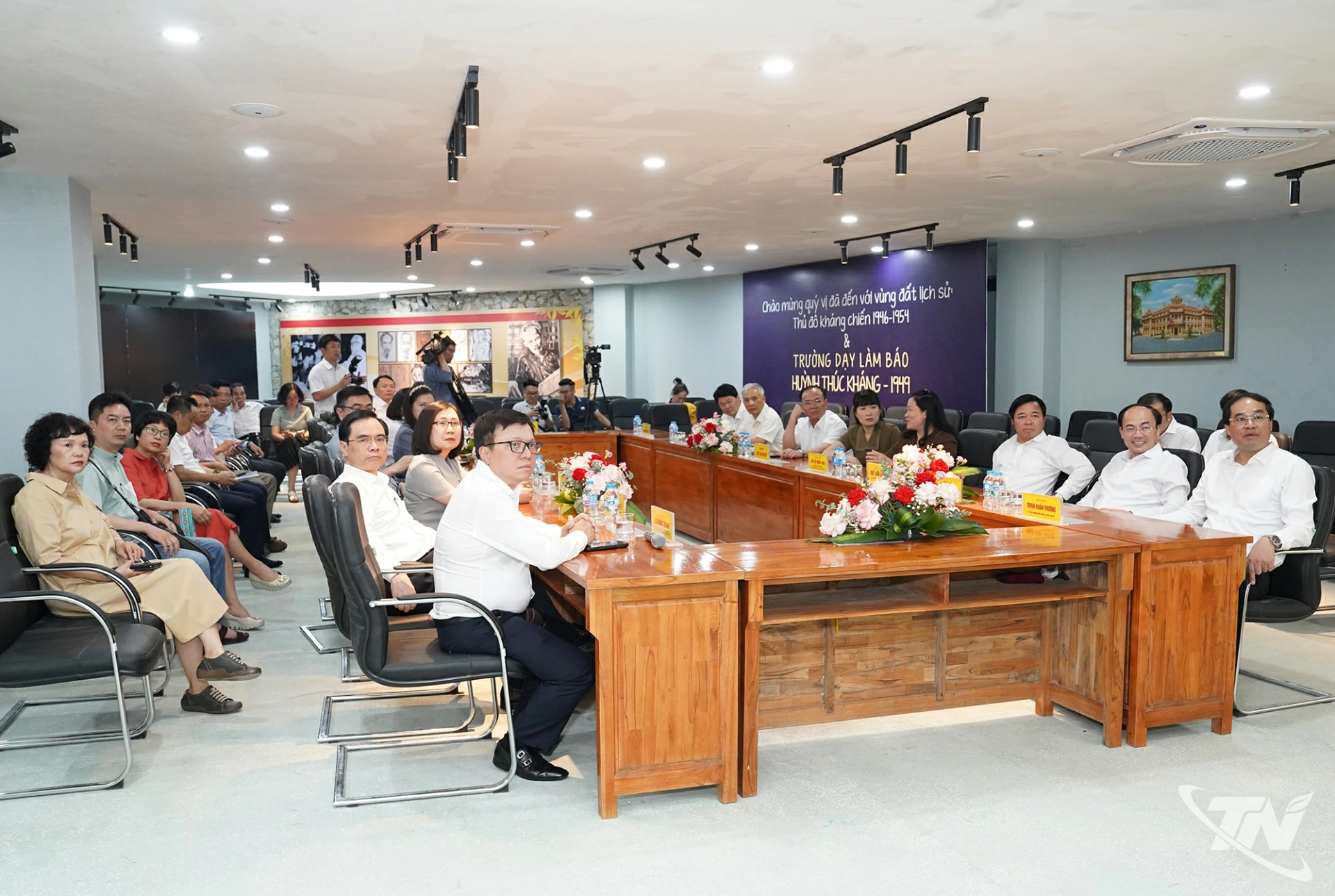 Các đại biểu xem phim tư liệu về Trường dạy làm báo Huỳnh Thúc Kháng.