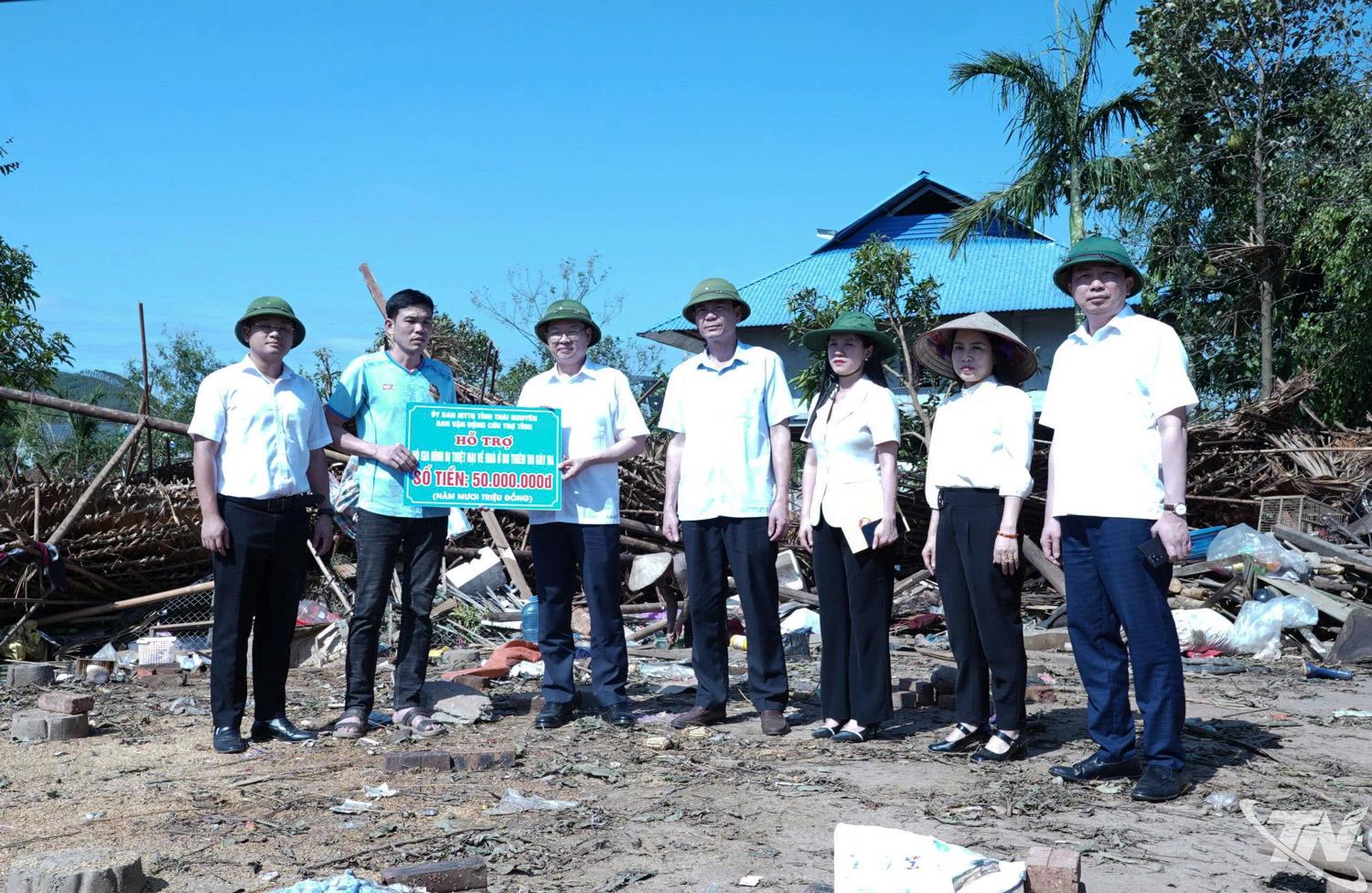Đồng chí Đinh Quang Tuyên, Phó Bí thư Tỉnh ủy, Chủ tịch Ủy ban MTTQ tỉnh trao tiền hỗ trợ cho gia đình ông Lường Trung Ngọc, xóm Làng Nông, xã Yên Trạch.