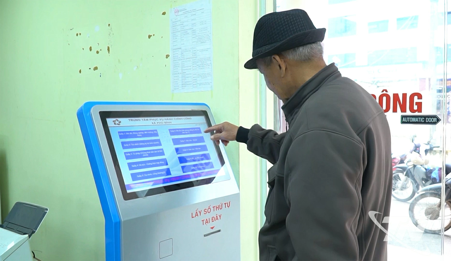 Người dân sử dụng thiết bị lấy số tự động tại TTPVHCC xã Phú Bình
