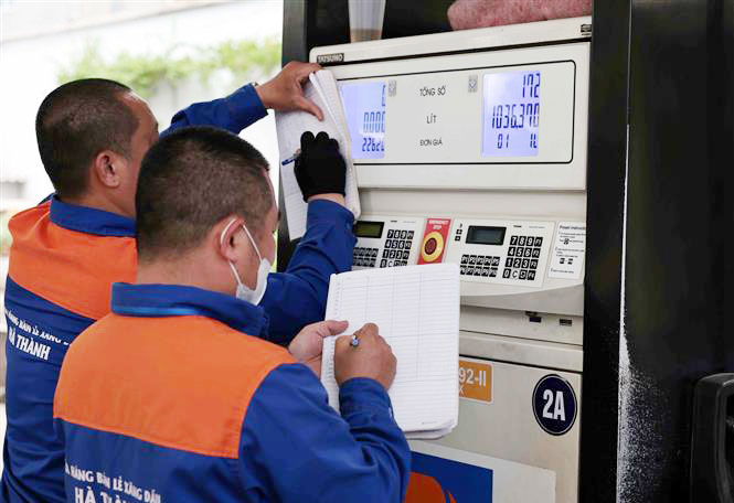 Kiểm k&ecirc; xăng dầu trước khi điều chỉnh gi&aacute; b&aacute;n. Ảnh: Trần Việt/TTXVN