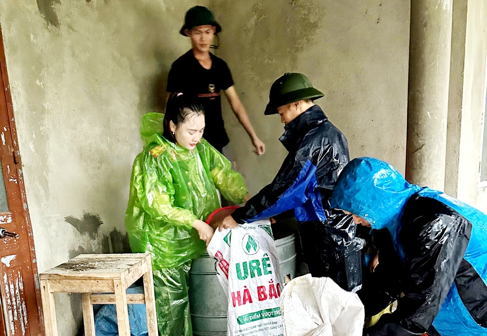 Lực lượng chức năng hỗ trợ người dân chuyển tài sản đến khu vực an toàn.