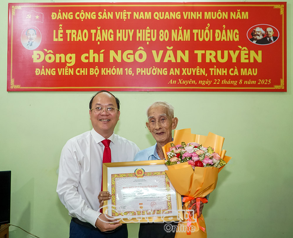 Bí thư Tỉnh ủy Nguyễn Hồ Hải trân trọng gắn Huy hiệu 80 năm tuổi Đảng cho đảng viên Ngô Văn Truyền.