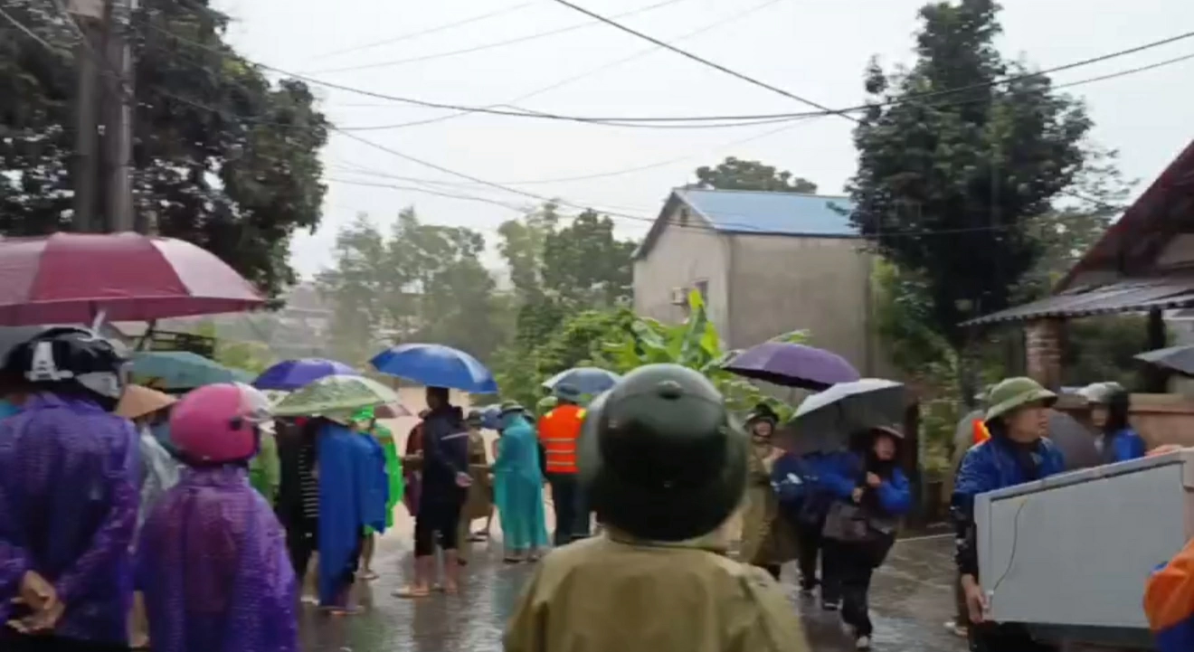 Lực lượng chức năng hỗ trợ hộ dân khu vực xung quanh di dời. 