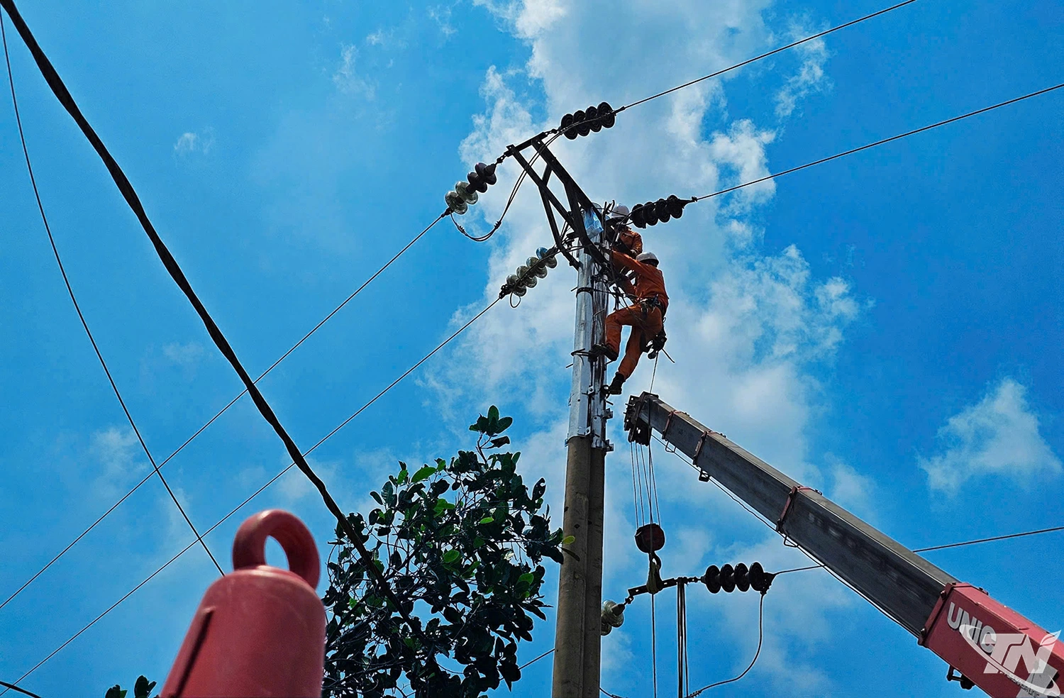 Công nhân điện lực thực hiện công tác sửa chữa, bảo dưỡng lưới điện trên cao trong điều kiện thời tiết nắng nóng, nhằm đảm bảo cung cấp điện an toàn, ổn định cho người dân.