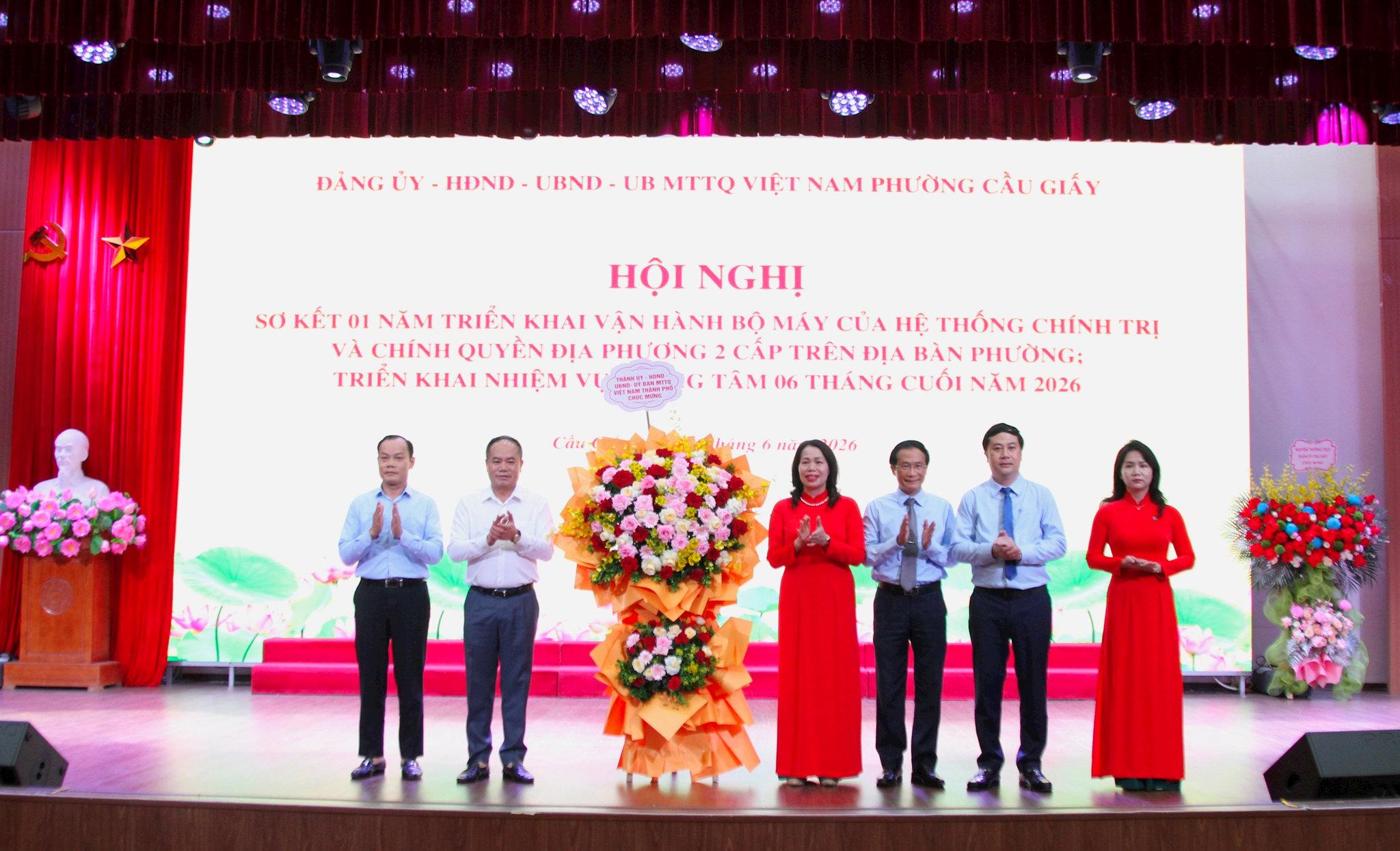Trung tướng Nguyễn Thanh Tùng, Giám đốc Công an thành phố Hà Nội tặng hoa chúc mừng lãnh đạo phường Cầu Giấy. Ảnh: Vân Nhi