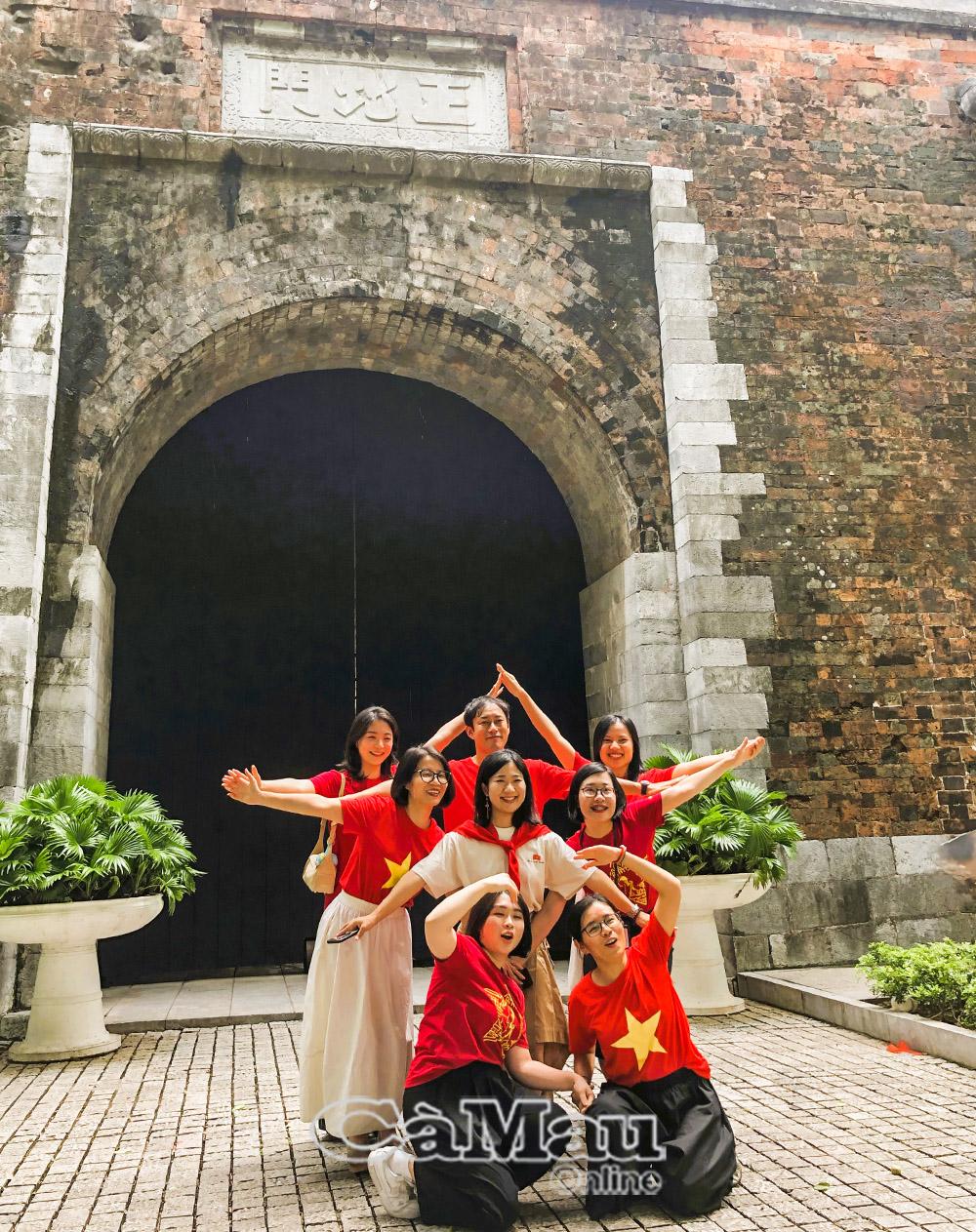 Các thiếu nữ tạo dáng hình ngôi sao trước cổng Bắc di tích Hoàng Thành Thăng Long.