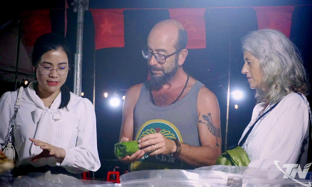 Du khách nước ngoài thưởng thức ẩm thực địa phương, tham quan gian hàng