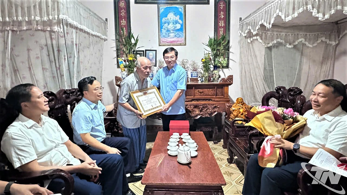 Đồng chí Nguyễn Thành Minh, Chánh Văn phòng Tỉnh ủy trao Huy hiệu 60 năm tuổi Đảng cho đảng viên Nguyễn Văn Khang.