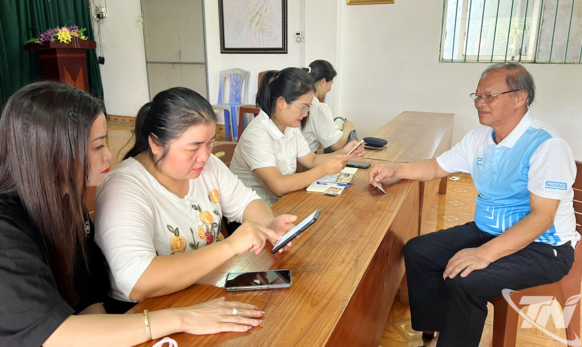 Tổ công nghệ số cộng đồng và đội xung kích tình nguyện tổ 5A, phường Bắc Kạn hỗ trợ người dân cài đặt dịch vụ số.