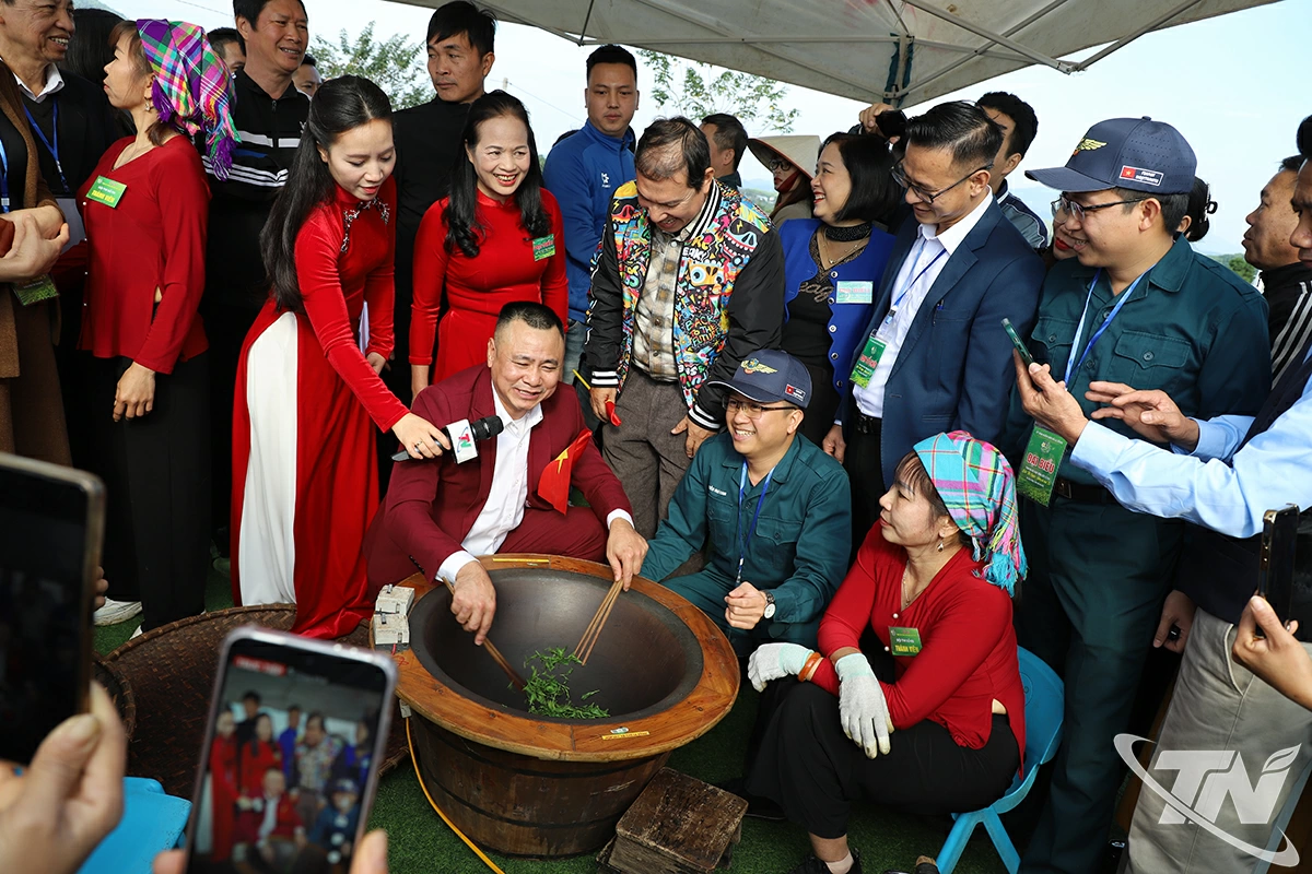 Các nghệ sĩ và du khách trải nghiệm chế biến chè.