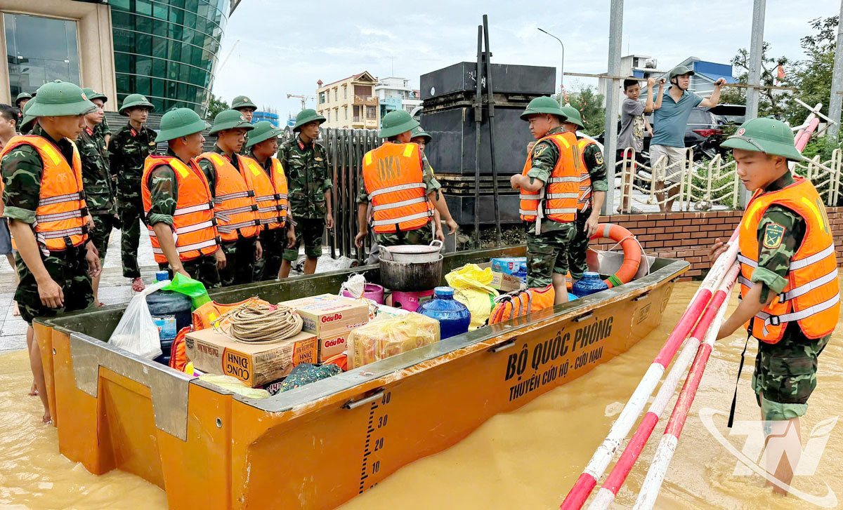 Lực lượng chức năng vận chuyển nhu yếu phẩm hỗ trợ các hộ dân ở khu vực ngập lụt.