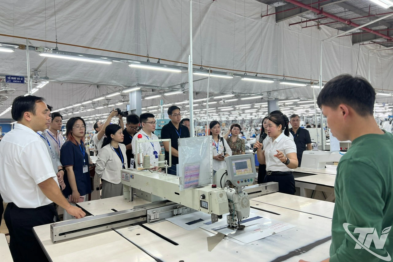 Đại diện Công ty giới thiệu về dây truyền tự động hoá trong khâu sản xuất hàng may mặc.