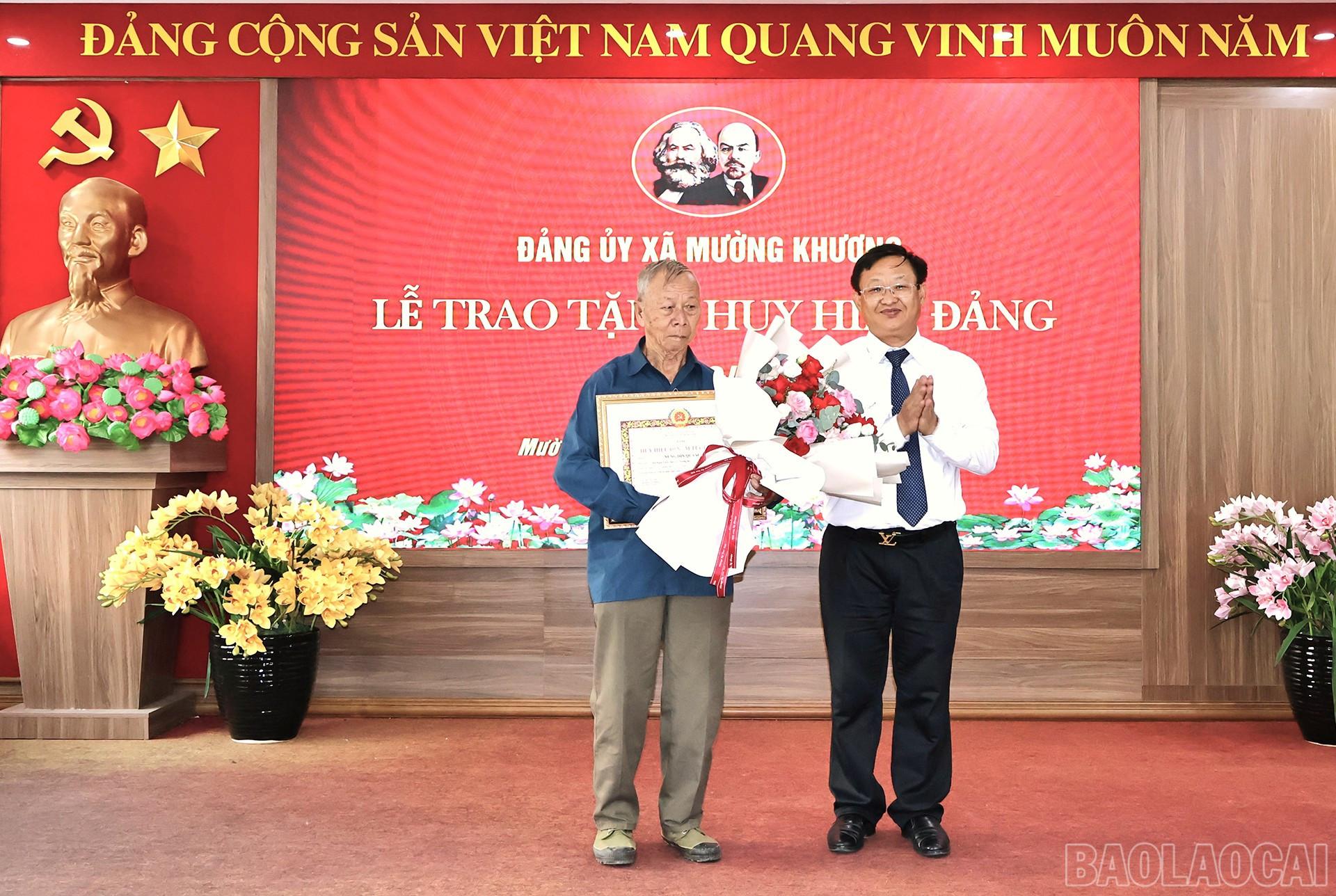 Đồng chí Giàng Seo Vần - Ủy viên Ban chấp hành Đảng bộ tỉnh, Bí thư Đảng ủy xã Mường Khương gắn vào trao huy hiệu 60 năm tuổi Đảng cho đảng viên Nùng Dỉn Quáng. baolaocai-br_31-8-mk60a.jpg