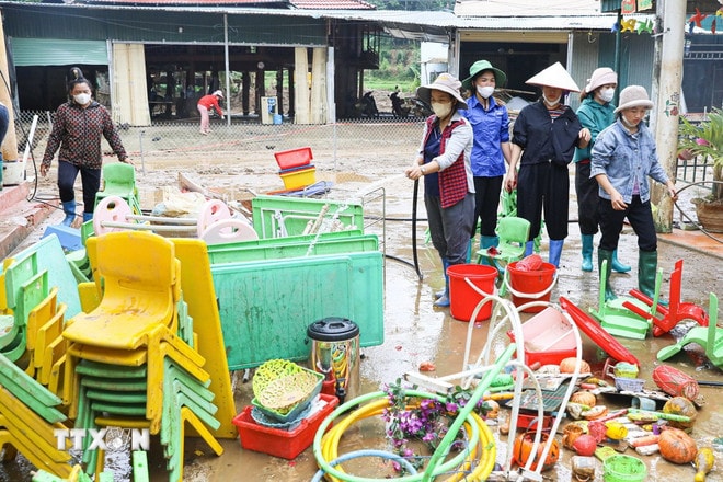 Cô giáo điểm trường Pá Vạt 1, Trường Mầm non Pá Vạt, xã Mường Luân (tỉnh Điện Biên) vệ sinh môi trường, bàn ghế sau mưa lũ. (Ảnh: Phan Quân/TTXVN) ttxvn-mua-lu-dien-bien-3.jpg
