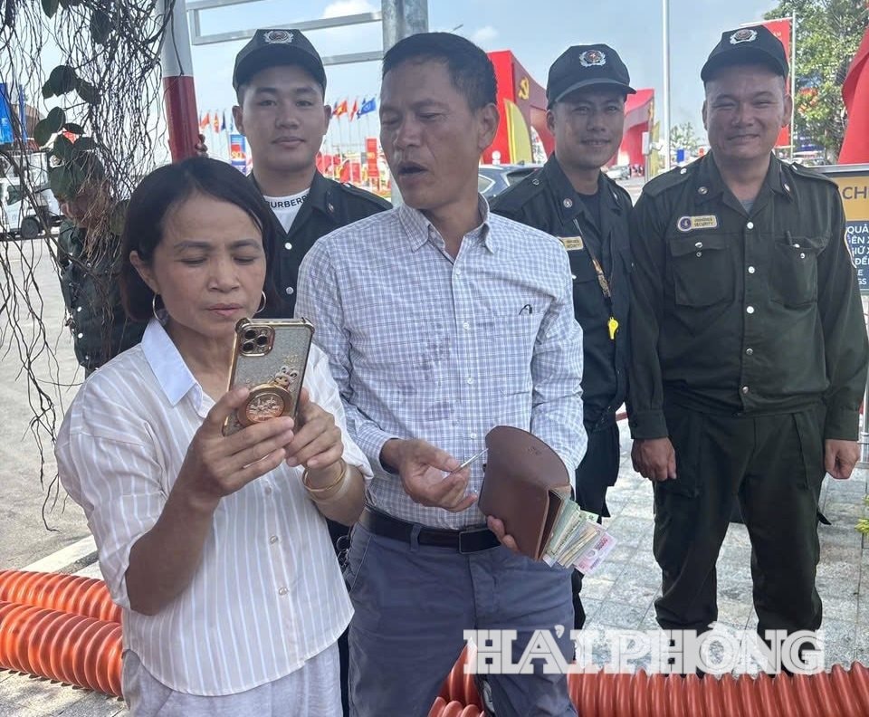 Chị Nguyễn Thị Vải được lực lương bảo vệ Triển lãm trao trả nguyên vẹn tài sản thất lạc. Ảnh từ facebook nhân vật