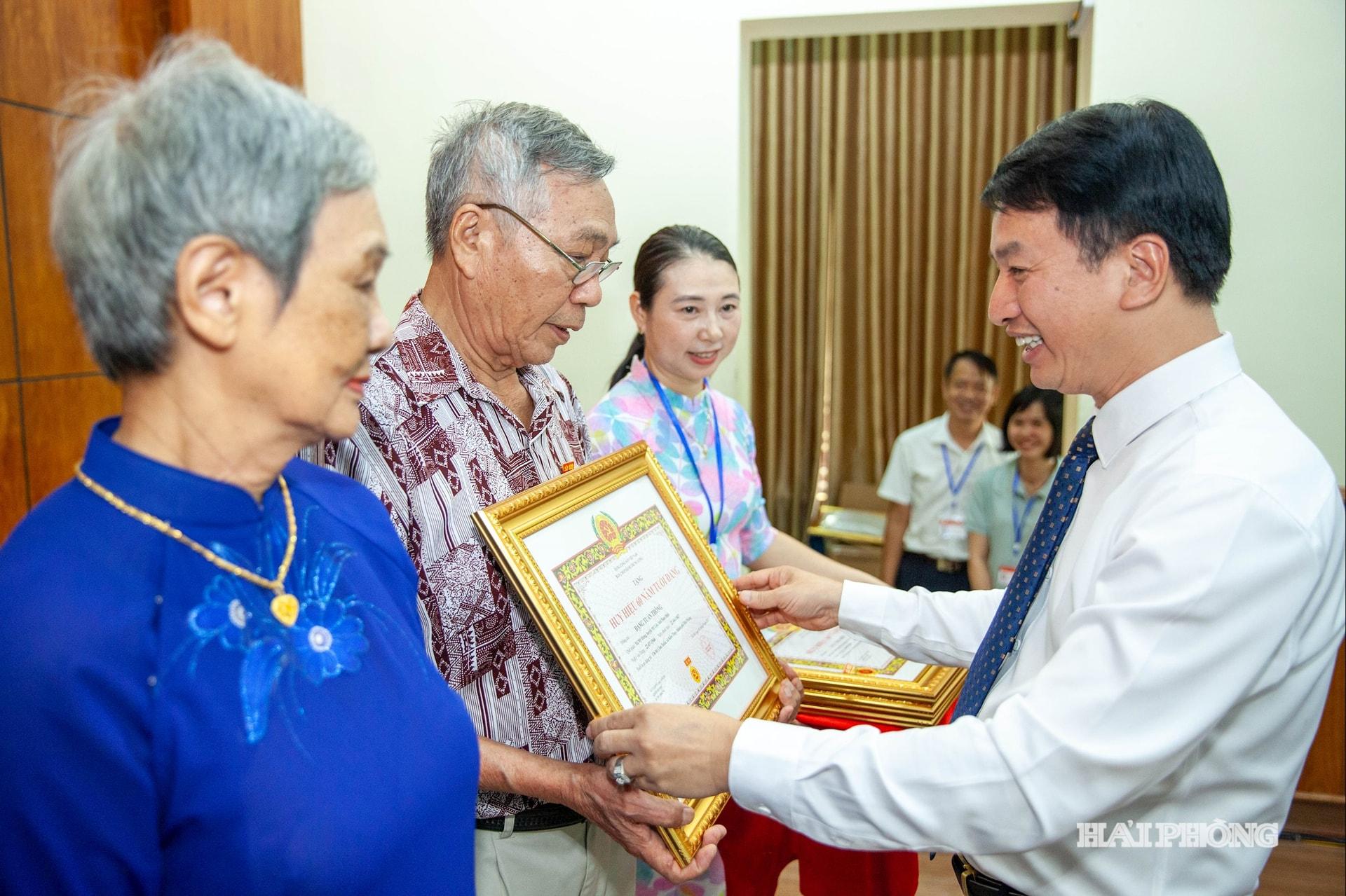 Đồng chí Nguyễn Đức Tuấn, Ủy viên Ban Thường vụ Thành ủy, Phó chủ tịch Thường trực Ủy ban MTTQ Việt Nam thành phố trao huy hiệu đảng tặng các đảng viên