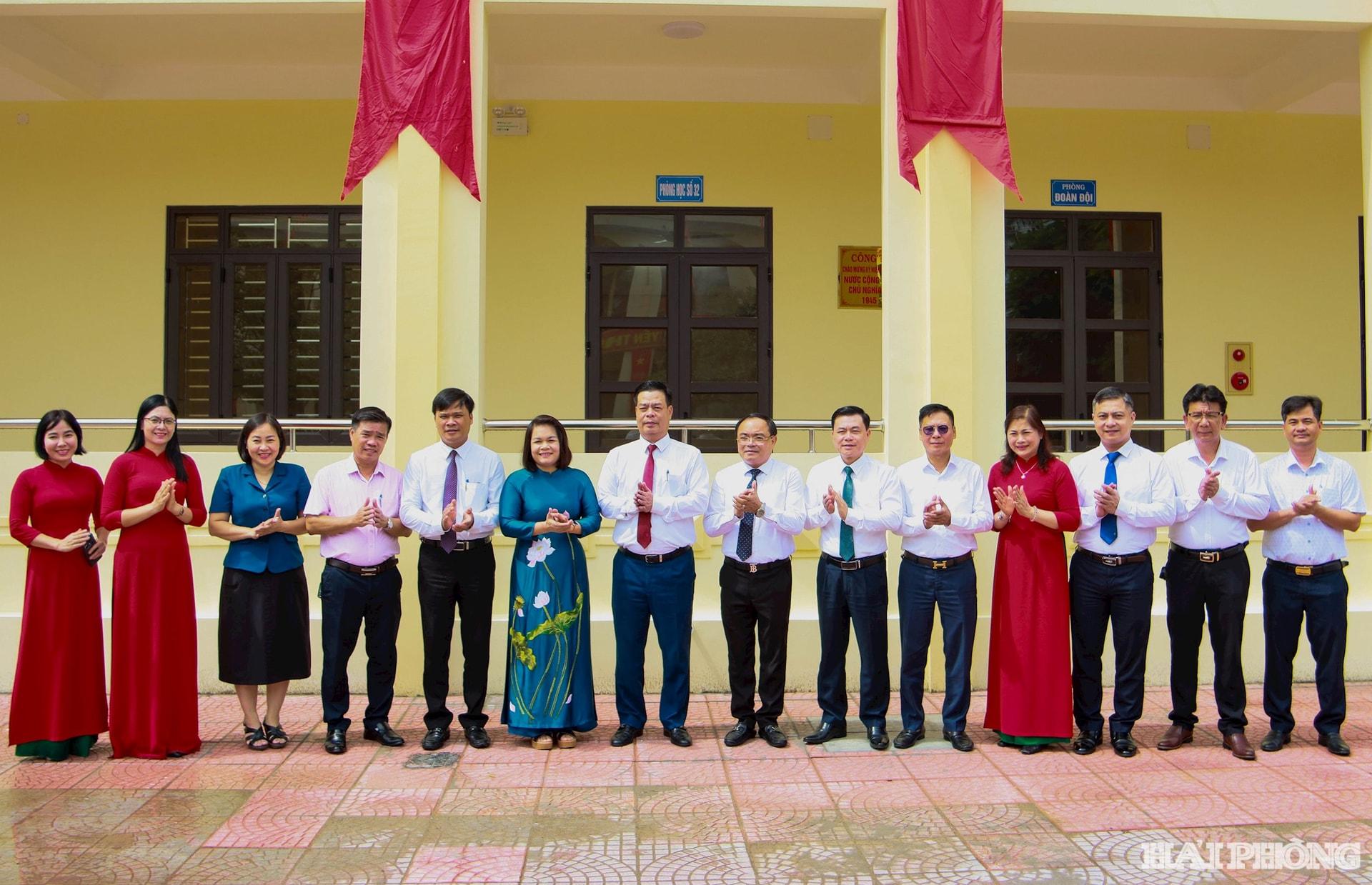 Các đại biểu thực hiện nghi thức gắn biển khu nhà lớp học 4 tầng trường THCS Lương Khánh Thiện