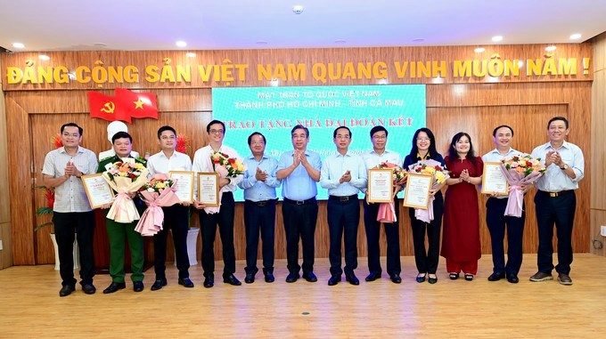 Đồng chí Nguyễn Phước Lộc cùng lãnh đạo Ủy ban MTTQ Việt Nam tỉnh Cà Mau tặng hoa cảm ơn các tập thể, cá nhân đồng hành, đóng góp kinh phí xây dựng nhà đại đoàn kết và các công trình dân sinh tại tỉnh Cà Mau. (Ảnh: SGGP)