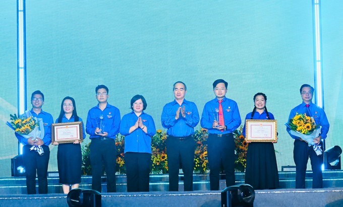 Đồng chí Nguyễn Thiện Nhân và đồng chí Văn Thị Bạch Tuyết chúc mừng các tập thể được trao Giải thưởng Hồ Hảo Hớn năm 2026. (Ảnh: SGGP)