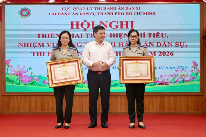 Thứ trưởng Bộ Tư Ph&aacute;p Mai Lương Kh&ocirc;i trao bằng khen cho c&aacute;c c&aacute; nh&acirc;n. (Ảnh: SGGP)