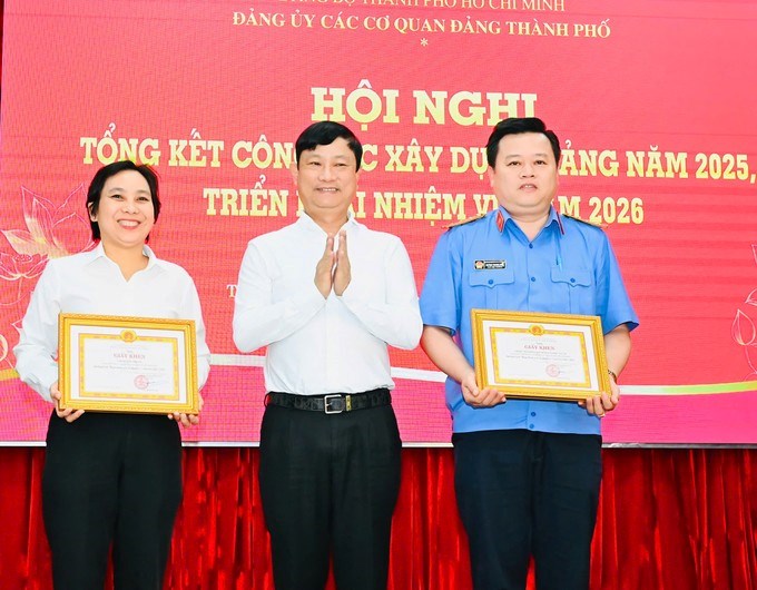 Chủ tịch HĐND TPHCM V&otilde; Văn Minh tặng Giấy khen của Đảng ủy c&aacute;c cơ quan Đảng TPHCM đến c&aacute;c tập thể .(Ảnh SGGP)