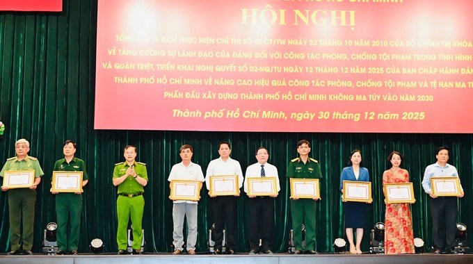 Thứ trưởng Bộ C&ocirc;ng an Nguyễn Văn Long trao bằng khen của Chủ tịch UBND TPHCM cho c&aacute;c tập thể, c&aacute; nh&acirc;n. (Ảnh: SGGP)